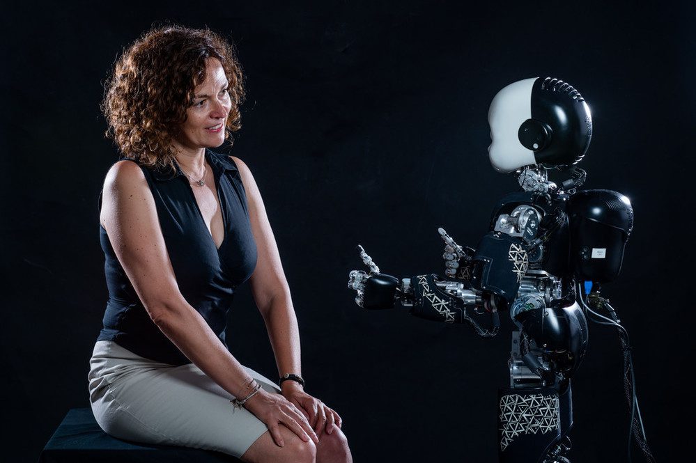 When humans play in competition with a humanoid robot, they delay their decisions when the robot looks at them